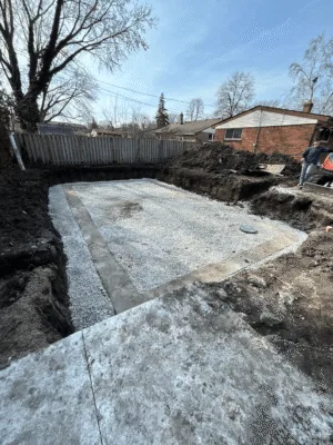 Excavation site in Windsor with gravel base prepared for concrete or pool installation.
